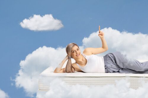 Frau auf Bett mit Wolken im Hintergrund