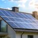 Solarzellen auf dem Dach eines modernen Hauses bei sonnigem Wetter installiert, die die Nutzung erneuerbarer Energien zeigen.