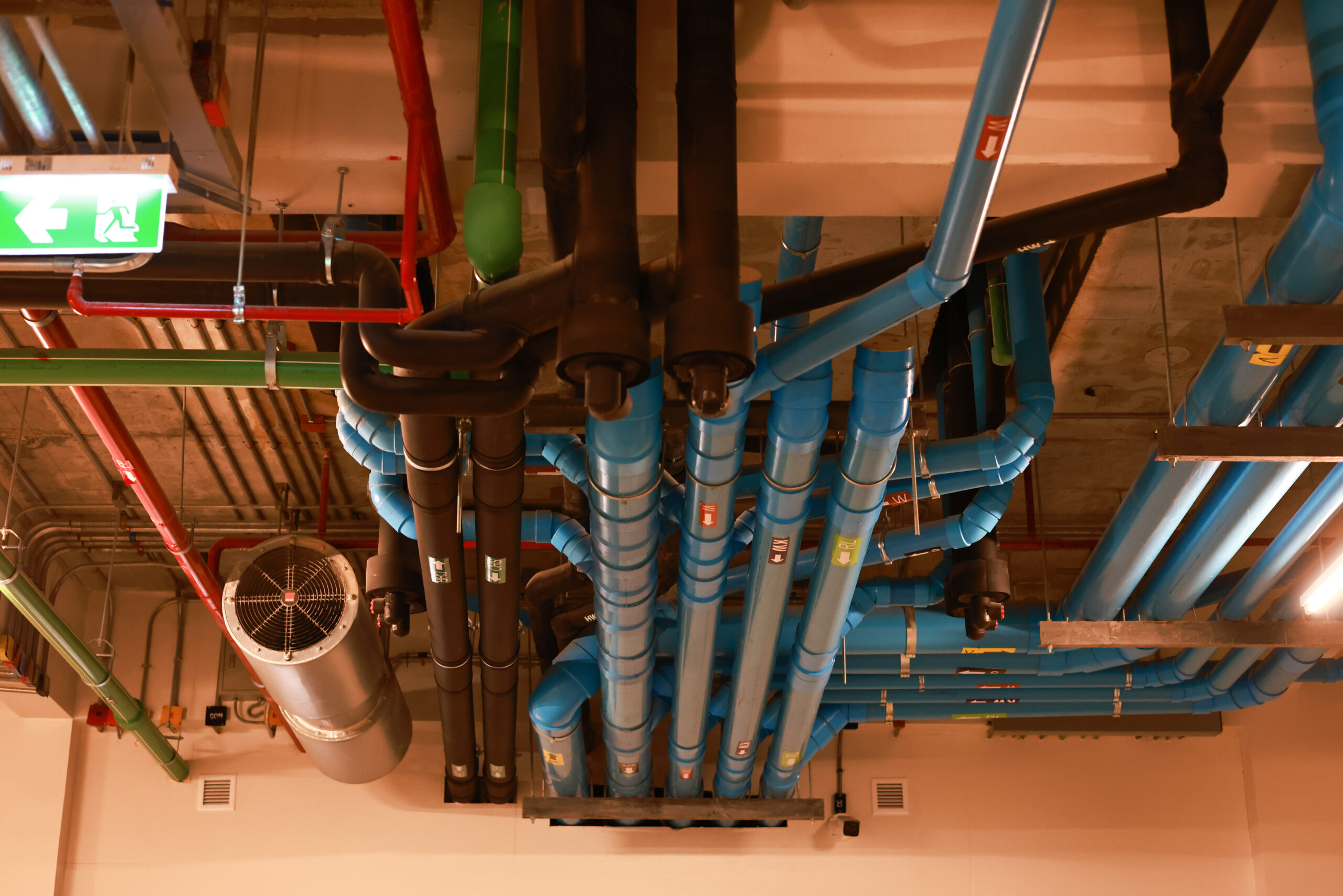 Komplexes Netzwerk aus blauen und schwarzen Rohren | Sachverständiger Brandmeldeanlagen